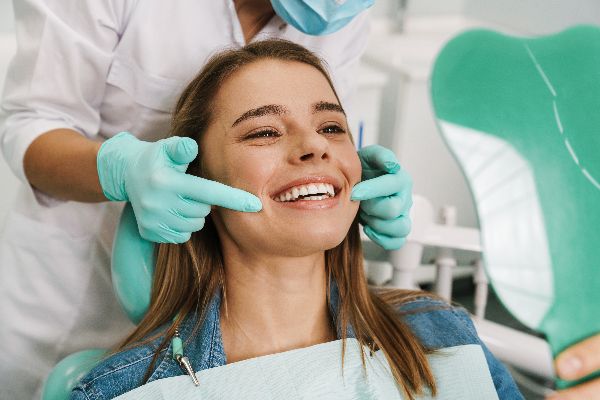smiling-woman-dental-checkup-dentist-pointing-teeth affordable dentist lilydale